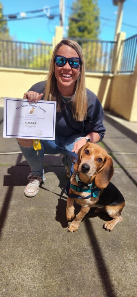 puppy and adult holding a certificate from passing puppy preschool